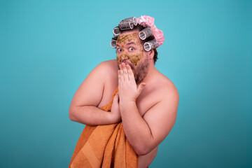 Beauty and skin care. Funny fat man washes in the shower in a cosmetic mask.