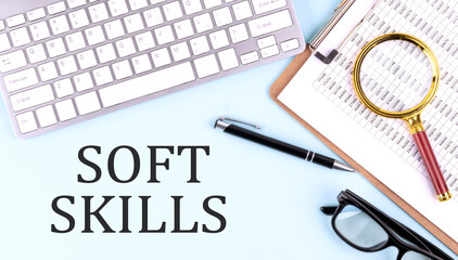 SOFT SKILLS text on blue background with keyboard and clipboard, business concept