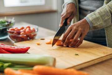 Obraz premium Close up view of vegetables on a table, cutting carrots on a chopping board