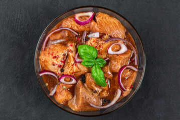 Raw pork or beef meat marinated in spices for cooking barbecue on black background. Top view