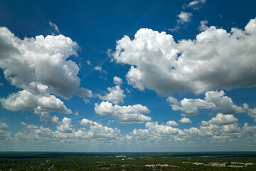 White puffy cumulus clouds on summer blue sky