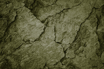 Olive green grunge background. Cracked rough stone surface. Close-up. Broken, crumbled.