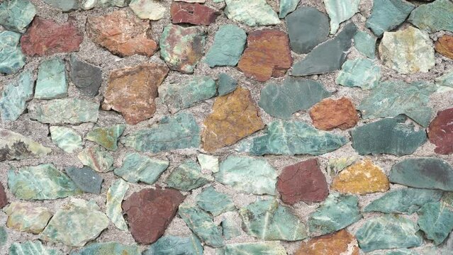 Wall of multi-colored stones of various shapes. Close-up