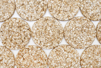 Background of round puffed rice cakes top view. Air crispy rice cakes with a minimum amount of calories for a healthy lifestyle. Low calorie diet food. Free space for text and ads