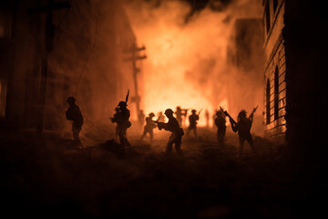 Fototapeta premium War Concept. Battle scene on war fog sky background, Fighting silhouettes Below Cloudy Skyline at night. City destroyed by war