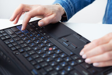 The girl is working on a laptop. Freelance, remote work, hands on the keyboard. View from above.