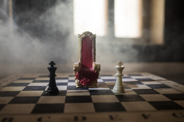 Red royal chair miniature on wooden table. Medieval Throne on chessboard. Chess board game concept...