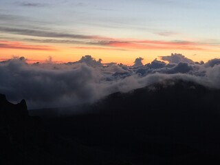 sunrise at the peak of the volcano with reds and orange colours in the clouds on the horizon