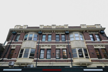 Fototapeta na wymiar Brown brick facade with cream color bay windows of heritage building on The Corso-Manly. Sydney-Australia-537