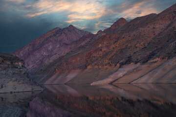 Beautiful sunset over the mountains and lake. Beautiful reflection in the water. 