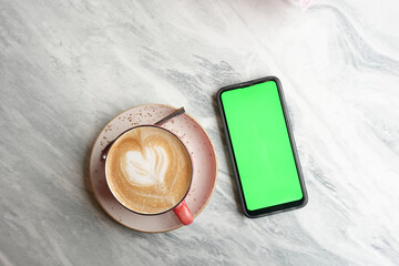 cpu of coffee and mart phone with green screen on table 