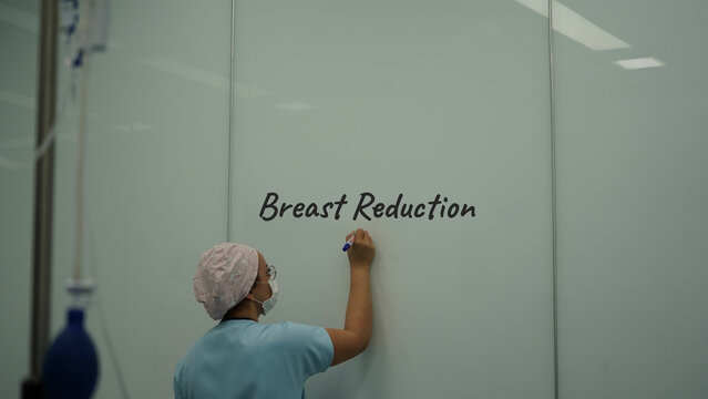 breast reduction surgery. Doctor doing breast reduction surgery with nurse