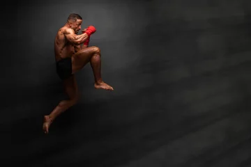 Foto op Aluminium Martial Art Fighter Performing Flying Knee Kick © mrbigphoto