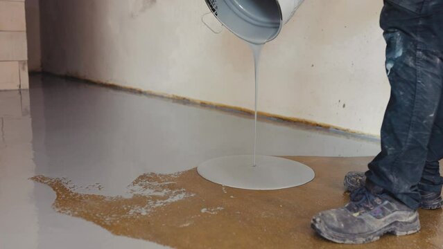Worker aply one type of flooring that is created by coating a concrete floor with a mixture of epoxy resin and hardener. 