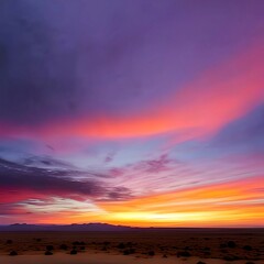 Obraz premium colorful pink, orange, and yellow sunset over a dark, barren desert