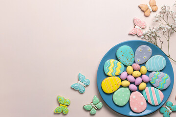 Easter banner on a pastel background. Homemade gingerbread cookies on a blue plate, Easter eggs and cookies in the shape of a rabbit and a butterfly. Easter concept.