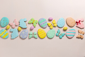 Fototapeta na wymiar Easter banner on a pastel background. Homemade gingerbread cookies on a blue plate, Easter eggs and cookies in the shape of a rabbit and a butterfly. Easter concept.