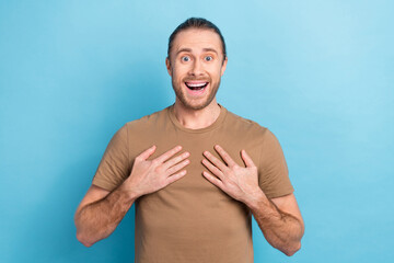 Photo of positive impressed man tail hairdo beige t-shirt arms on chest unexpected winning betting...