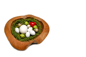 Holzschale mit Osternest, verschiedenen Eiern und rotem Herz