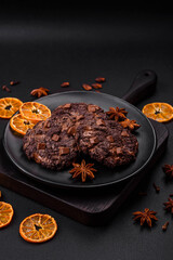 Delicious fresh oatmeal round cookies with chocolate on a black ceramic plate