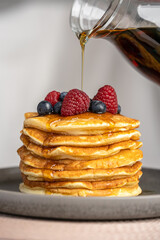 Pancakes with berries and maple syrup stock photo