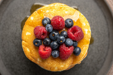 Pancakes with berries and maple syrup stock photo