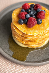 Pancakes with berries and maple syrup stock photo