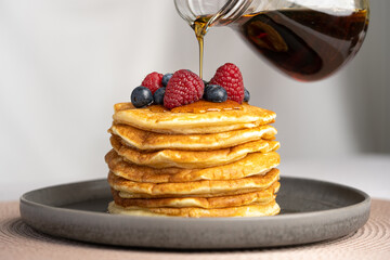 Pancakes with berries and maple syrup stock photo