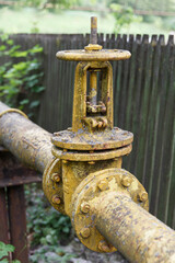 Fototapeta na wymiar Gas pipe with large old valve-crane.