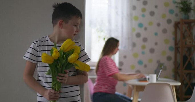 A son gives his beloved mother a beautiful bouquet of yellow tulips