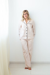 Carefree young woman in cozy pajamas resting at home - wellbeing and comfort morning concept