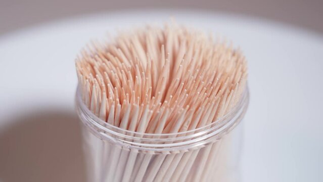 Container with wooden toothpick on the table