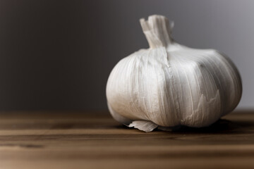 Weiße ganze Knoblauchknolle vor dunkelgrauem Hintergrund