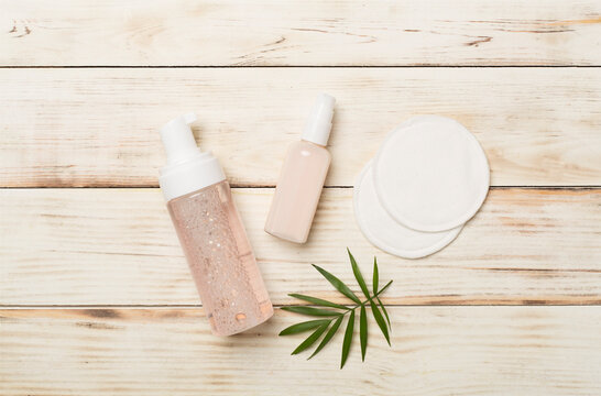 Face care products with eco pads on wooden background, top view