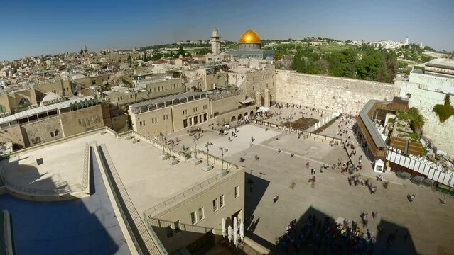 The Jewish shrine of the Wailing Wall in the old city of Jerusalem against the backdrop of the Al-Aqsa Mosque and many people. Top view of the historic city center of Jerusalem. time lapse fast