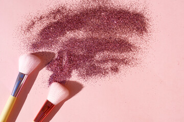 Minimal modern cosmetic scene with set of make up brushes set over pink background with glitter and shadow overlay