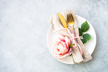 Spring Table setting with white plate and rose flowers. Table decor for an anniversary or wedding.
