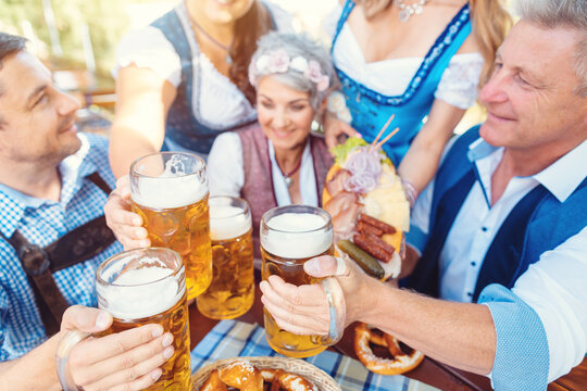 Group of friends toasting in Bavarian beer garden