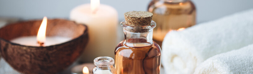 Concept of spa treatment in salon with pure organic natural oil. Atmosphere of relax, detention. Aromatherapy, candles, towel, wooden background. Skin care, body gentle treatment