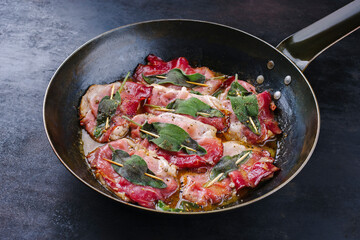 Traditional Italian fried pork saltimbocca alla Romana with Parma ham and sage leaves served as...