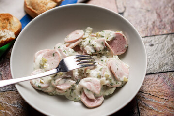 Delicious salad made from mix of chopped sausages, spices, sour cream and potatoes.