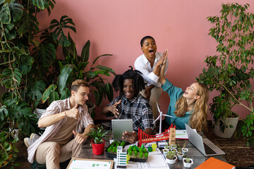 International group of students working on modern urban architecture project with renewable green energy source, alternative electricity, waste recycling. Excited and happy to win ecology contest