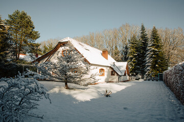 beautiful farmhouse in Germany, in winter. White old farmhouse covered in snow. House with a large...