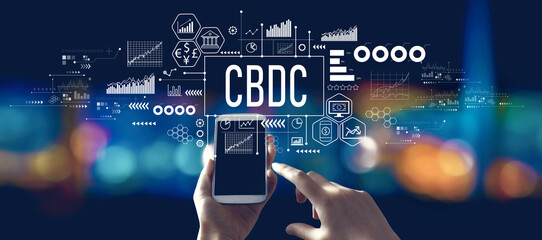 CBDC - Central Bank Digital Currency Concept with person using a smartphone in a city at night