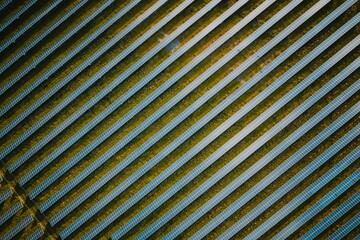 Solar panel rows aerial view. Photovoltaic panels farm from the sky, diagonal rows for renewable solar energy. Reducing  carbon footprint concept, clean green energy for the future. © Benoît