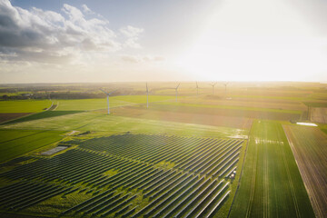 Wind turbines and solar panels farm in a field. Renewable green energy. Sunny landscape, electric energy generator for clean energy producing concept.