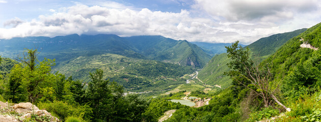 Tskhenistsqali river valley panorama in Racha region of Georgia with Svaneti mountain range, lush green forests and vineyards seen from to Khvamli Mountain.