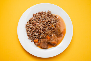 Boiled buckwheat with meat and sauce on white dish