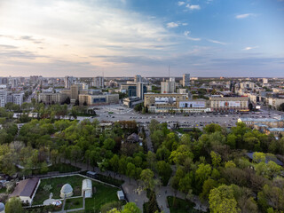Fototapeta na wymiar Aerial view on Svobody Square and historic buildings from park with sunset sky. Kharkiv, Ukraine in spring