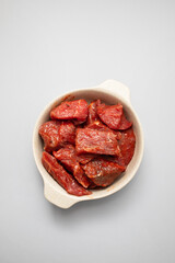 Fresh raw cube of beef in white bowl